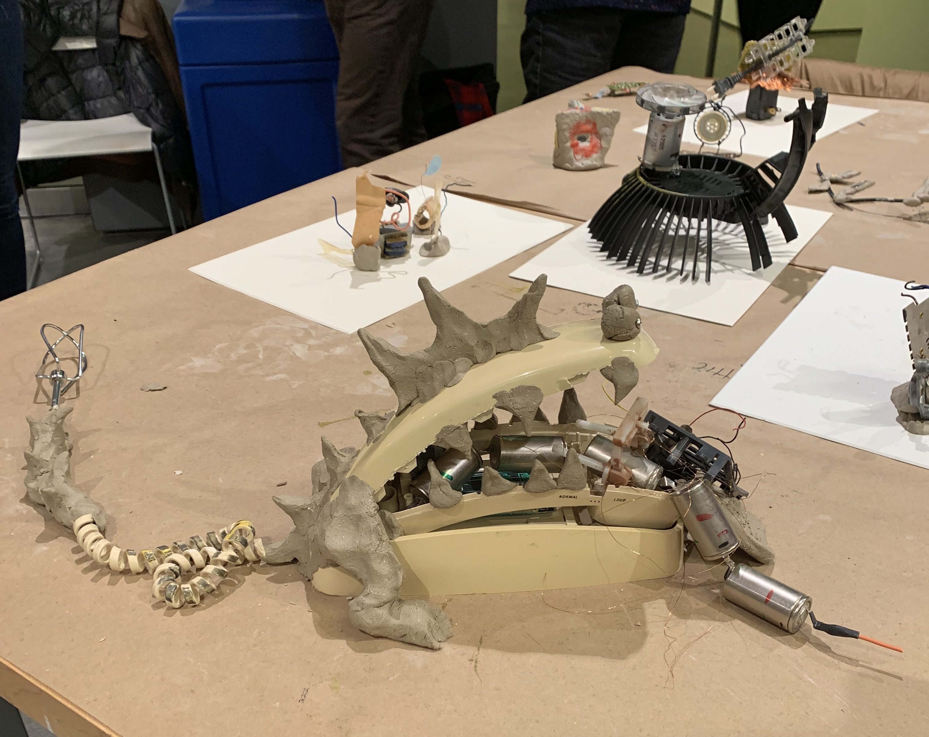 This is a picture of disassembled mechanical objects, remade into other assemblages. Specifically featured here is a large-mouthed monster with a phone-receiver serving as its jaw.